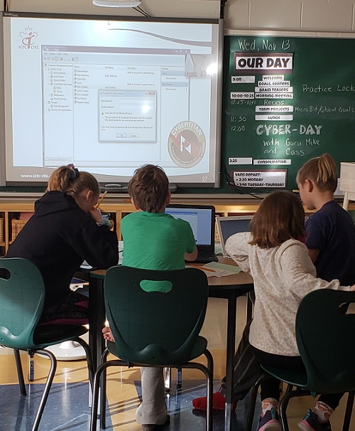 Children working on computers in a classroom.